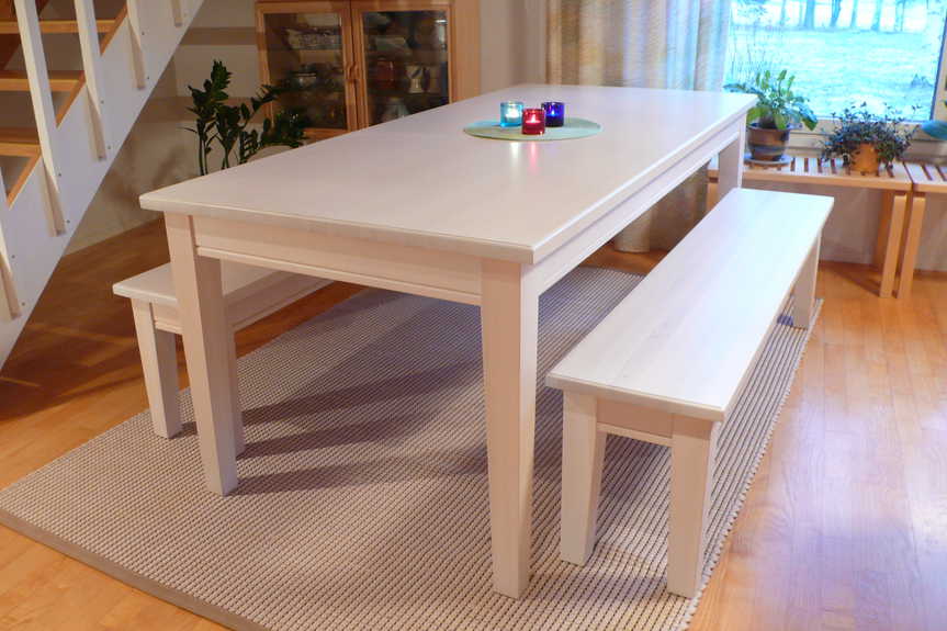 Koivusta tehty, perinteinen pirttipöytä ja penkit modernilla valkolakkauksella.