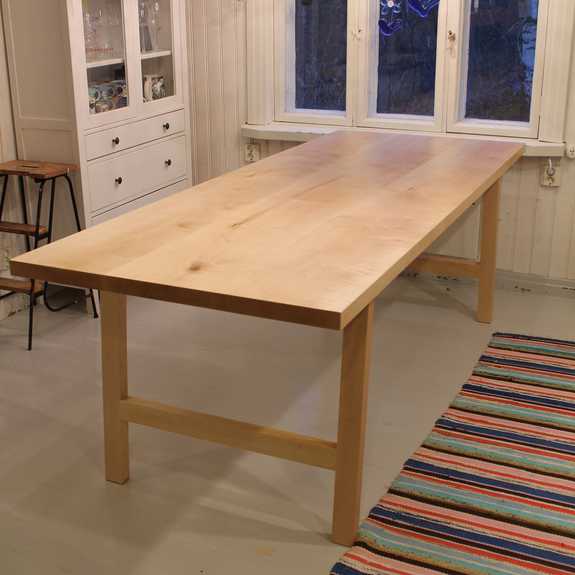 Koivupuisen lankkupöydän kansi on tehty kolmesta järeästä lankusta. Runko ja kansi on käsitelty vahalla.